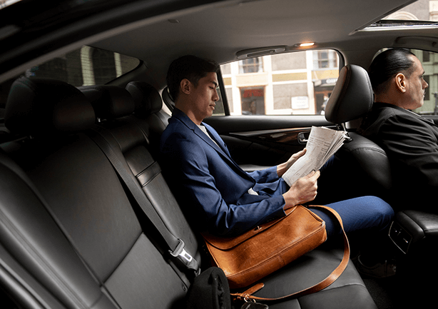 Professional drivers and dispatchers standing in front of luxury vehicles